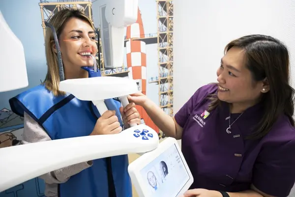 Eine Zahnärztin führt eine moderne digitale Röntgenaufnahme bei einer Patientin durch.