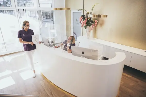 Moderne Zahnarztpraxis mit Empfangsbereich, freundlichem Personal und heller Einrichtung.